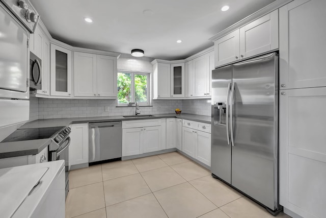 kitchen with light tile patterned flooring, stainless steel appliances, white cabinetry, and sink