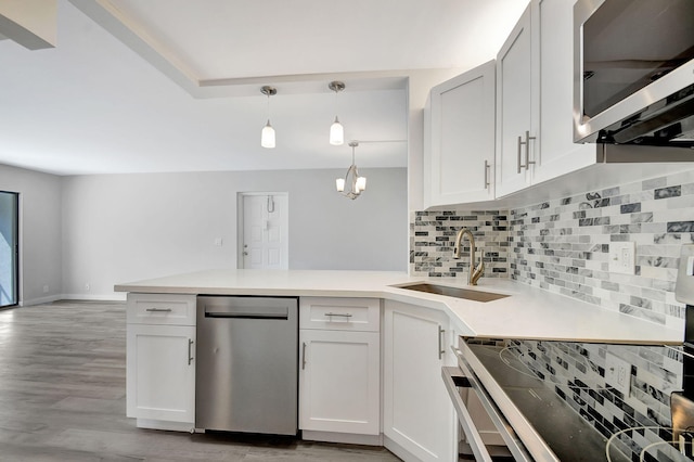 811 Sky Pine Way Unit D2, Greenacres, FL 33415 - kitchen featuring stainless steel appliances, a sink, a peninsula, tasteful backsplash, and light wood-style floors
