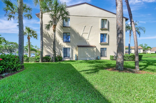 811 Sky Pine Way Unit D2, Greenacres, FL 33415 - rear view of house featuring stucco siding and a lawn