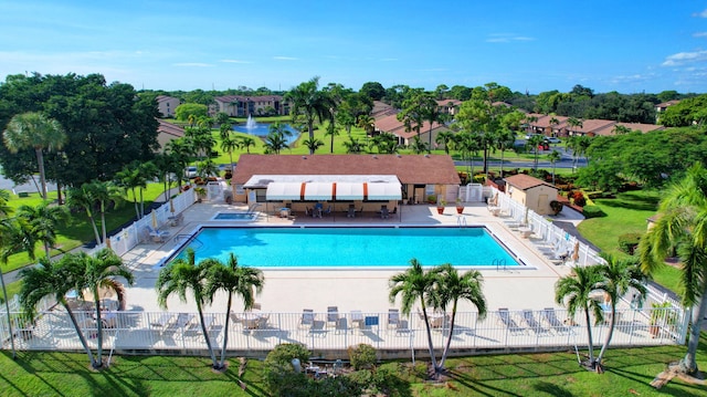 view of swimming pool with a patio, a water view, and a lawn