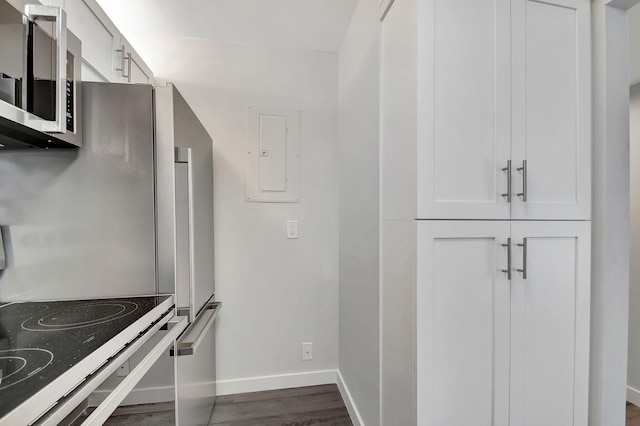 kitchen with white cabinetry, electric panel, stove, and hardwood / wood-style floors