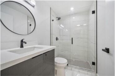 bathroom with vanity, toilet, and an enclosed shower