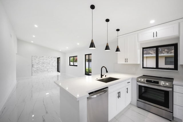 kitchen with hanging light fixtures, kitchen peninsula, sink, white cabinetry, and appliances with stainless steel finishes