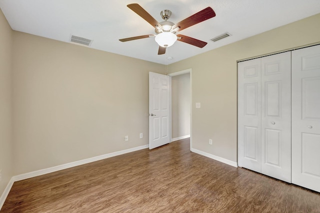 unfurnished bedroom featuring a closet, ceiling fan, and dark hardwood / wood-style floors