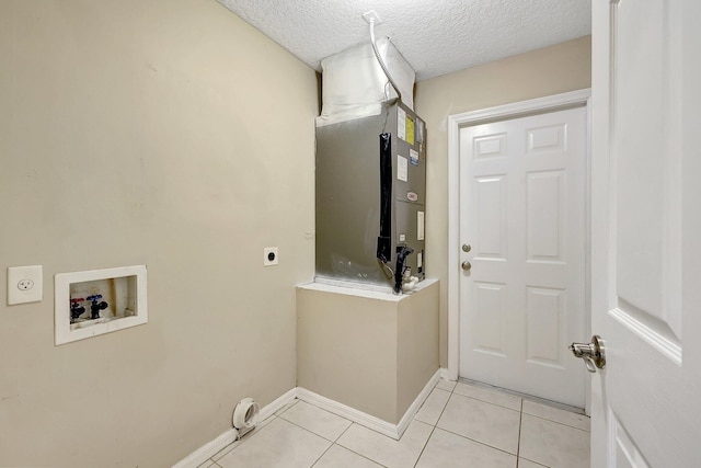 laundry area with hookup for an electric dryer, a textured ceiling, washer hookup, and light tile patterned floors