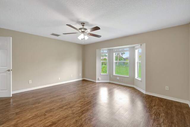 spare room featuring ceiling fan, dark hardwood / wood-style floors, and a textured ceiling