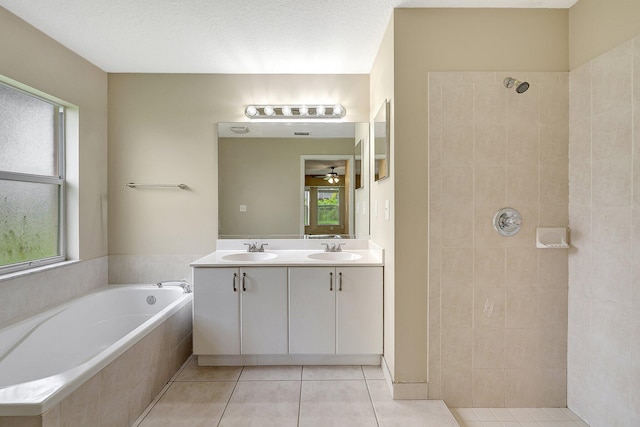 bathroom with tile patterned floors, separate shower and tub, a textured ceiling, vanity, and ceiling fan