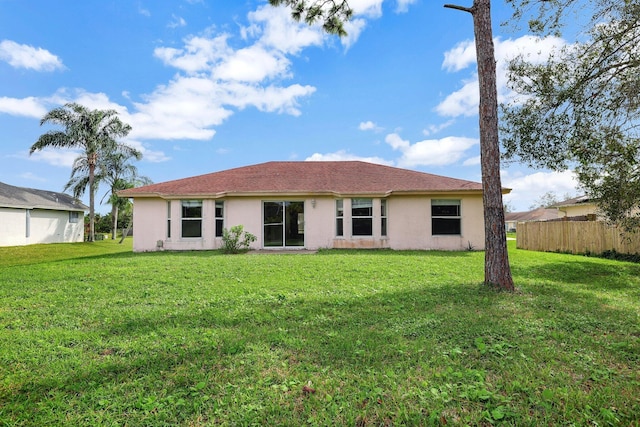 rear view of house featuring a lawn