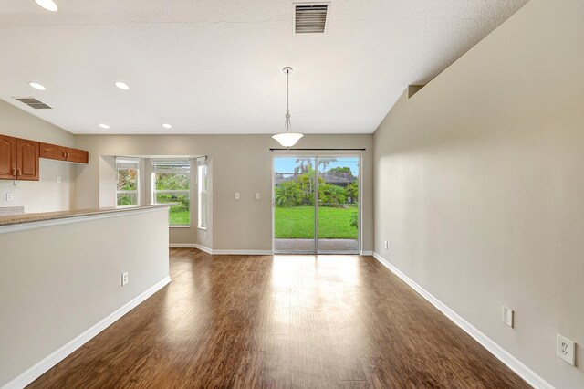 interior space featuring a wealth of natural light, lofted ceiling, and dark hardwood / wood-style flooring