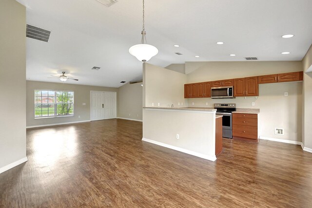 kitchen featuring appliances with stainless steel finishes, dark hardwood / wood-style floors, pendant lighting, lofted ceiling, and ceiling fan