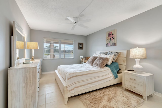 tiled bedroom with ceiling fan and a textured ceiling