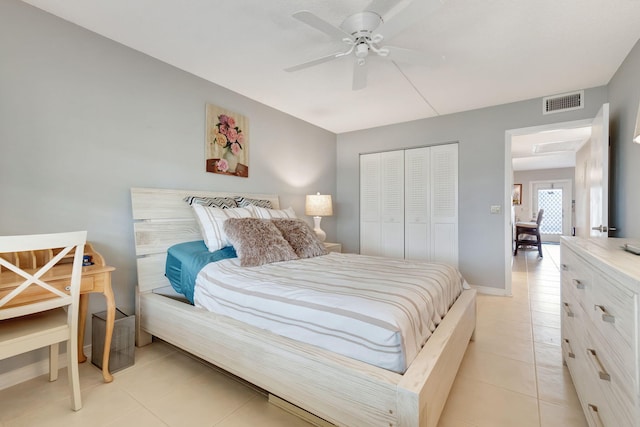 bedroom with a closet, light tile patterned floors, and ceiling fan