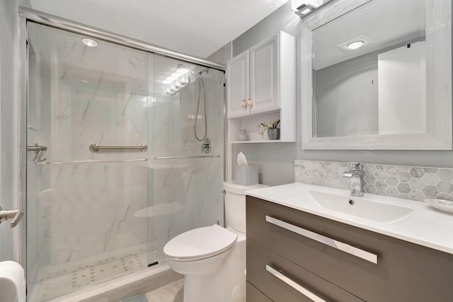 bathroom featuring vanity, toilet, walk in shower, and decorative backsplash