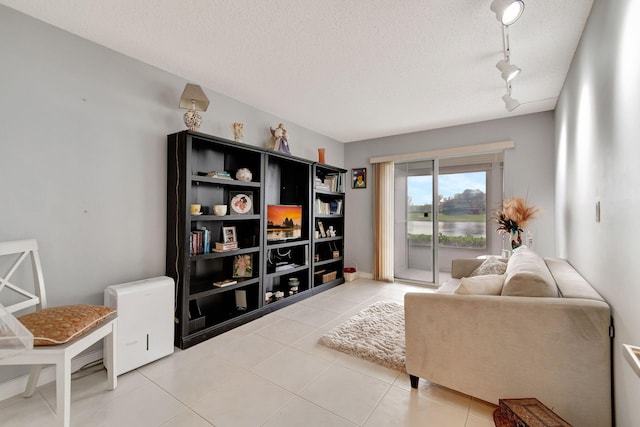 sitting room featuring a textured ceiling, tile patterned flooring, and rail lighting