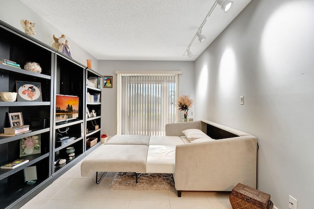 sitting room with track lighting, a textured ceiling, and light tile patterned floors