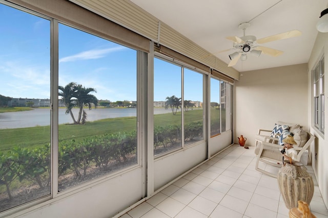 sunroom / solarium with a water view and ceiling fan