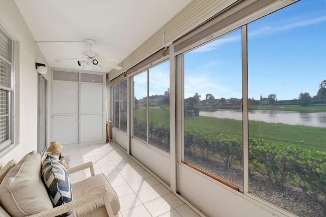 sunroom featuring a water view and ceiling fan