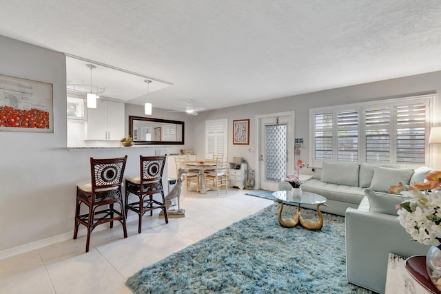 living room with a textured ceiling and light tile patterned floors