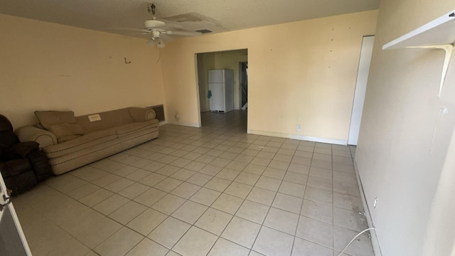 unfurnished living room with light tile patterned floors and ceiling fan