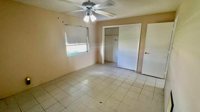 unfurnished bedroom featuring light tile patterned flooring, ceiling fan, and a closet