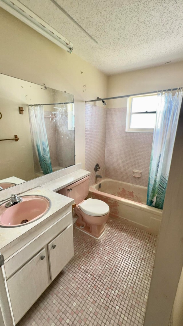 full bathroom featuring vanity, toilet, a textured ceiling, and shower / tub combo