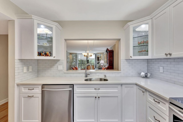 kitchen featuring decorative backsplash, white cabinetry, dishwasher, and sink