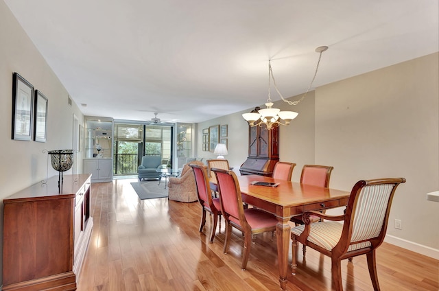 dining area featuring light wood-type flooring and ceiling fan with notable chandelier