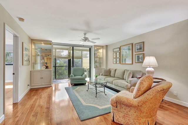 living room with ceiling fan, a healthy amount of sunlight, and light hardwood / wood-style flooring