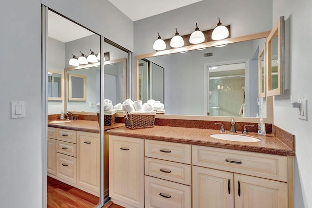 bathroom with vanity, a shower with shower door, and hardwood / wood-style flooring