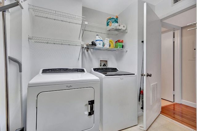 laundry area with light hardwood / wood-style flooring and washing machine and clothes dryer