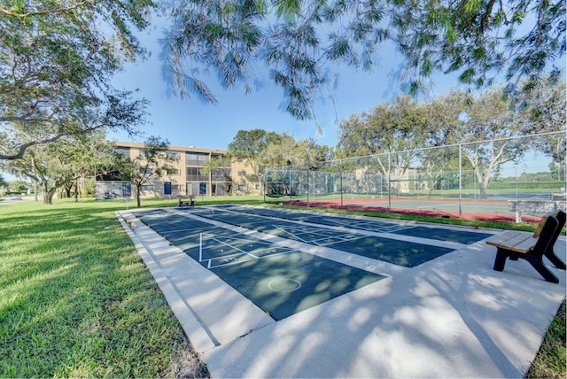 view of tennis court featuring a lawn