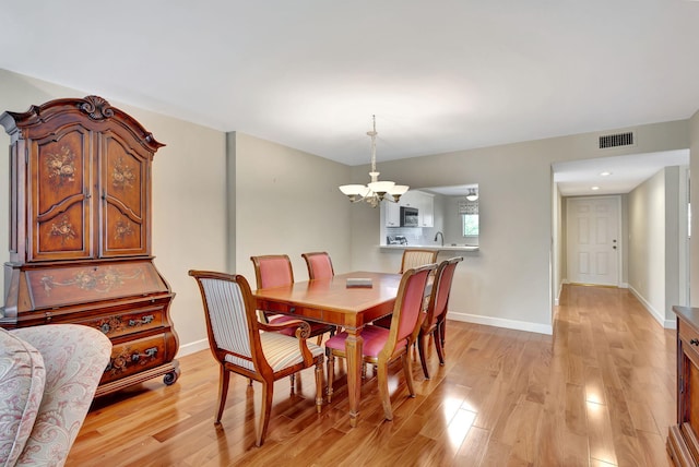 dining area featuring an inviting chandelier and light hardwood / wood-style flooring