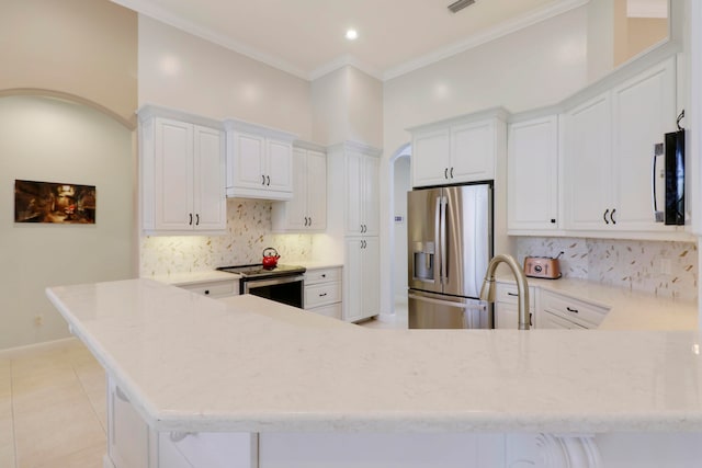 kitchen with kitchen peninsula, light tile patterned floors, appliances with stainless steel finishes, white cabinetry, and ornamental molding