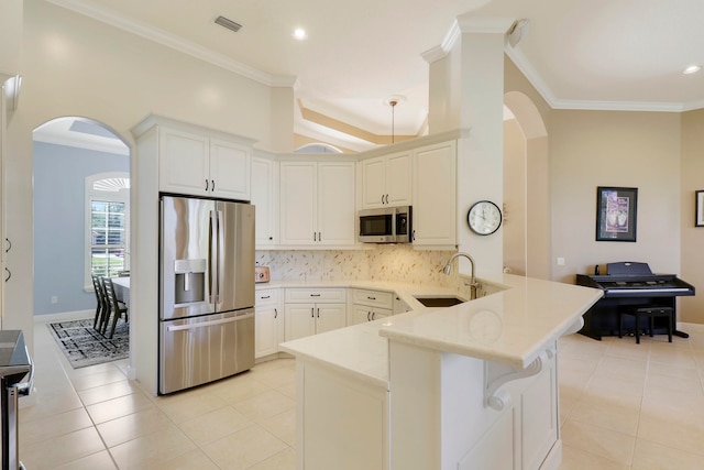 kitchen featuring kitchen peninsula, ornamental molding, sink, white cabinetry, and appliances with stainless steel finishes