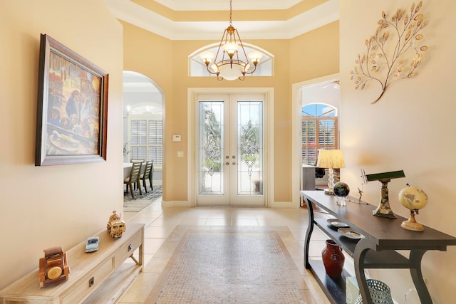 entryway with french doors, a chandelier, and light tile patterned floors