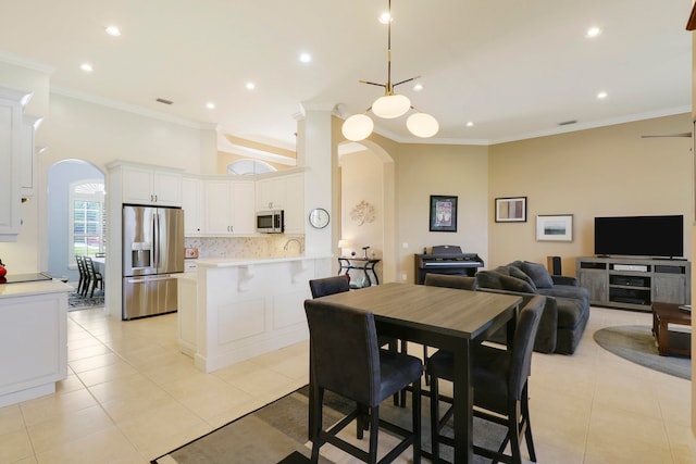 dining space with ornate columns, ornamental molding, and light tile patterned flooring