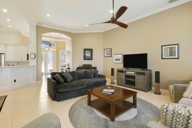 living room featuring ornamental molding, light tile patterned floors, and ceiling fan with notable chandelier