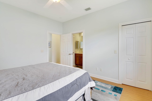 bedroom with a closet, ceiling fan, wood-type flooring, and ensuite bathroom