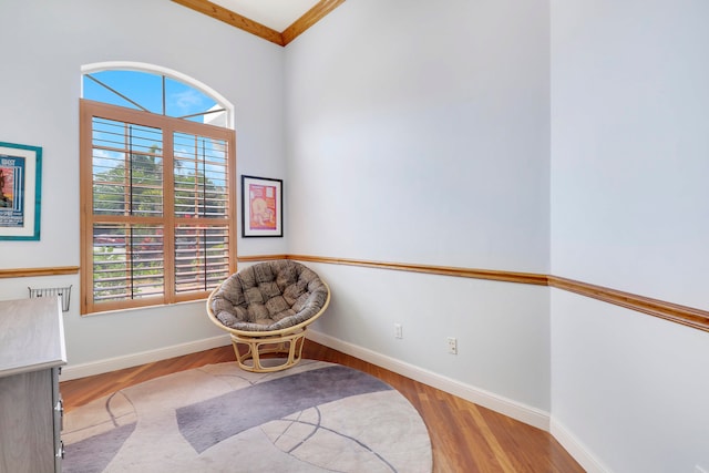 sitting room with light hardwood / wood-style floors and crown molding