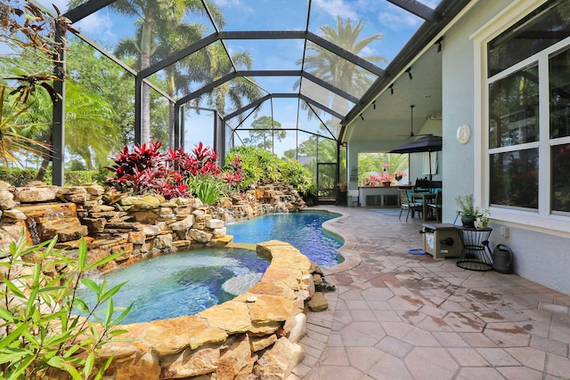 view of pool with an in ground hot tub, ceiling fan, a patio, and a lanai