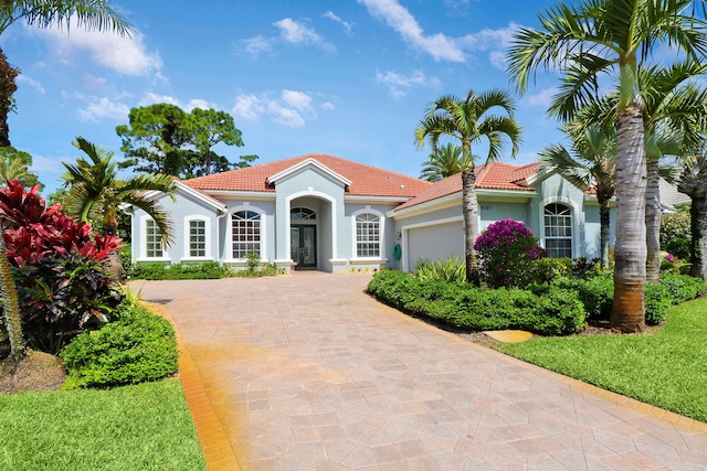 mediterranean / spanish house with a front yard and a garage