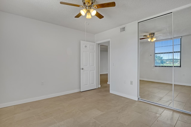 unfurnished bedroom with a textured ceiling, a closet, and ceiling fan