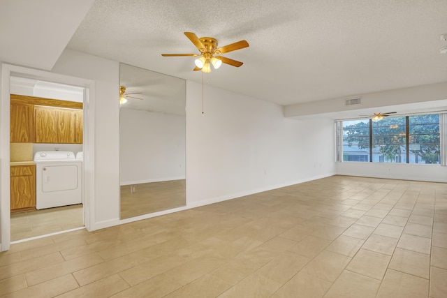 unfurnished room with a textured ceiling, washer and clothes dryer, and ceiling fan