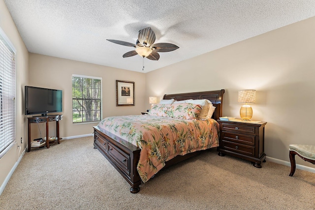 carpeted bedroom featuring ceiling fan and a textured ceiling