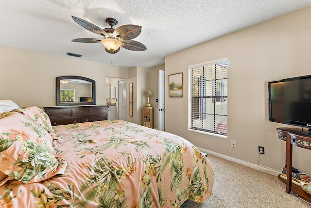 bedroom with a textured ceiling, light colored carpet, and ceiling fan