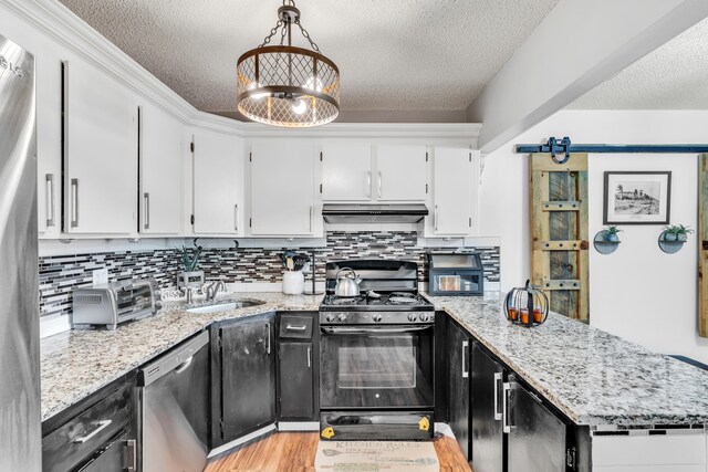 kitchen with pendant lighting, light hardwood / wood-style floors, appliances with stainless steel finishes, and white cabinets