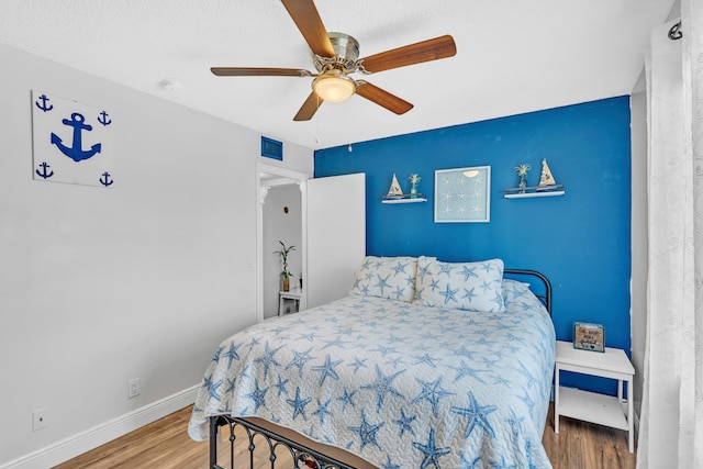 bedroom with wood-type flooring and ceiling fan