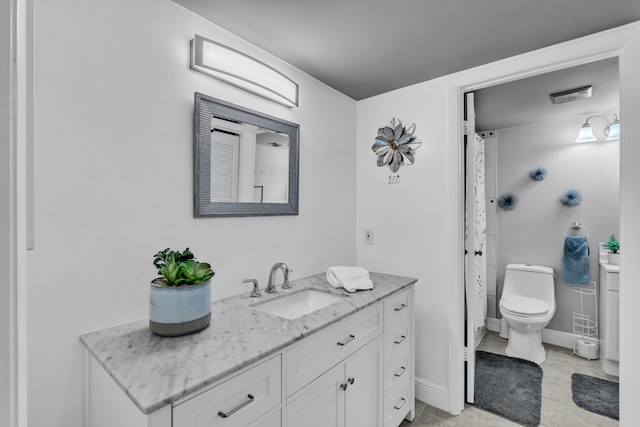 bathroom with toilet, vanity, and tile patterned floors