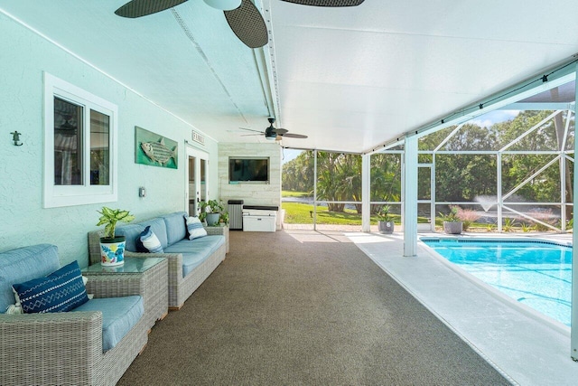 view of swimming pool with outdoor lounge area, a patio area, glass enclosure, and ceiling fan