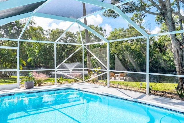 view of swimming pool featuring a lawn and glass enclosure